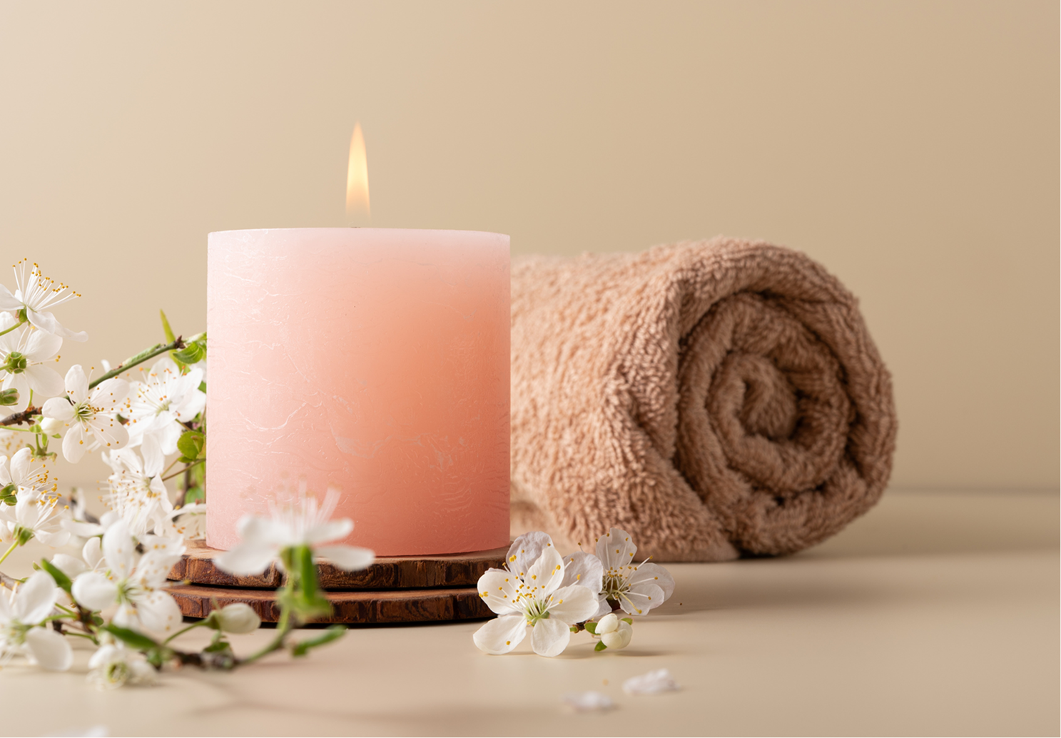 Pink candle with flowers and towel
